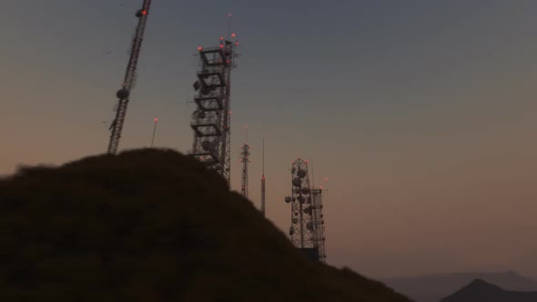 Loopable camera spin around an antenna complex on a hill during sunset. 4k