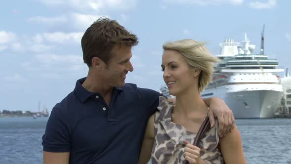 Romantic couple near a harbour with cruise ship in background