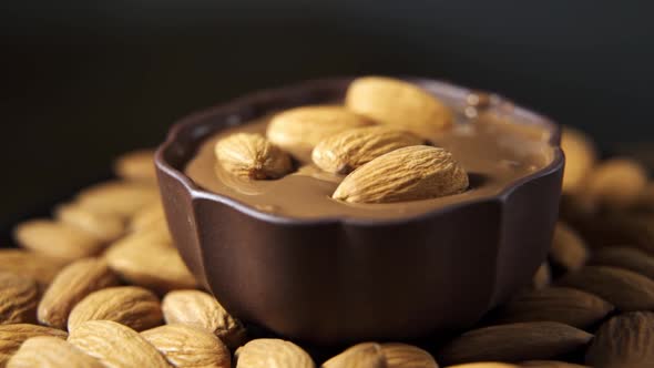 Pouring Hot Melted Chocolate and Almond Nuts Texture Close Up