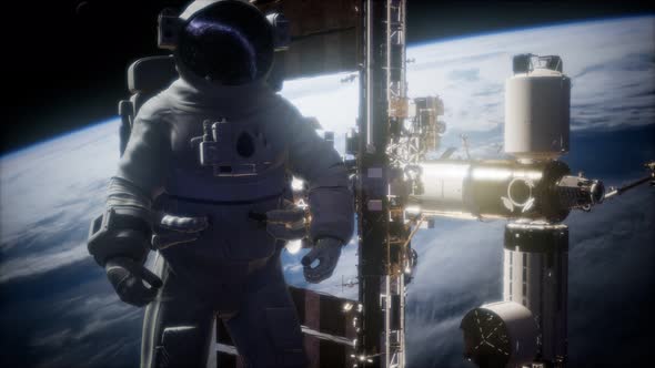 International Space Station and Astronaut in Outer Space Over the Planet Earth alt