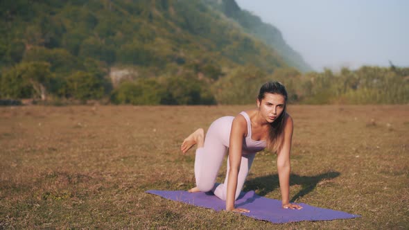 Athletic Woman Exercising on the Sea Coast and Doing Donkey Kicks