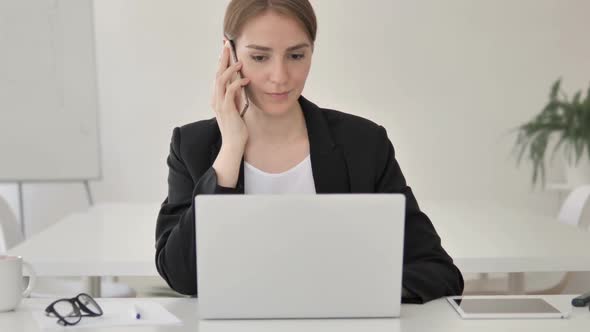 Young Businesswoman Using Smartphone at Work