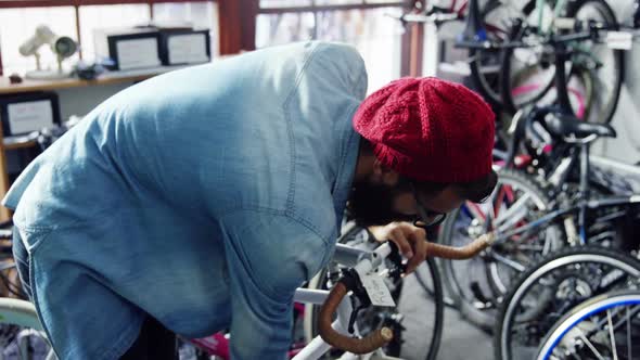 Mechanic repairing bicycle in workshop