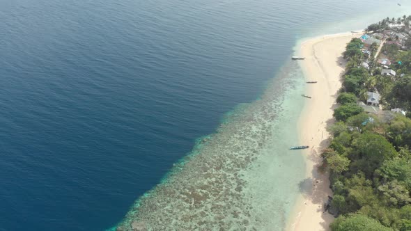 Aerial: flying over tropical Hatta island white sand beach Banda Islands Maluku