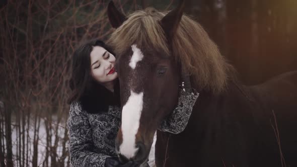 A Young Brunette Cowgirl Taking Care of Mare Riding Horse While Winter Season at Countryside