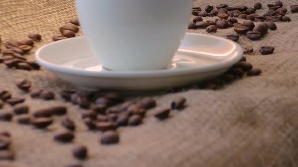 A cup of coffee with coffee beans in a rustic style in a cafe on a bar counter.