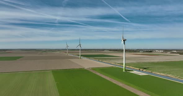 Dutch landscape with typical wind turbines and a water canal.