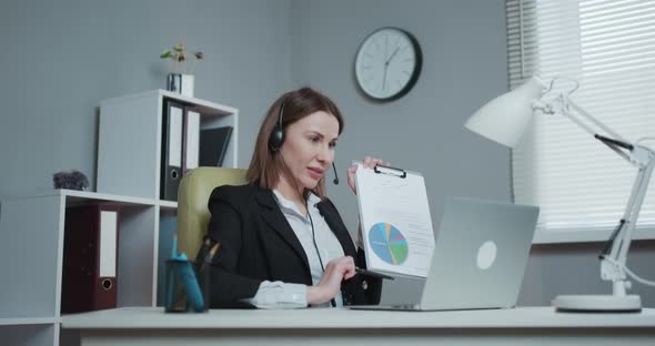 Businesswoman Holding Paper Financial Report Talk at Webcam make Video Call in Office