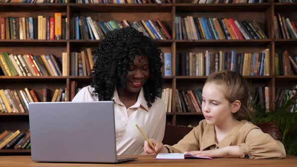 Black Tutor and Schoolgirl Give Each Other Five at Table