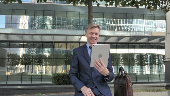 Online Video Chat on Tablet By Businessman in Suit