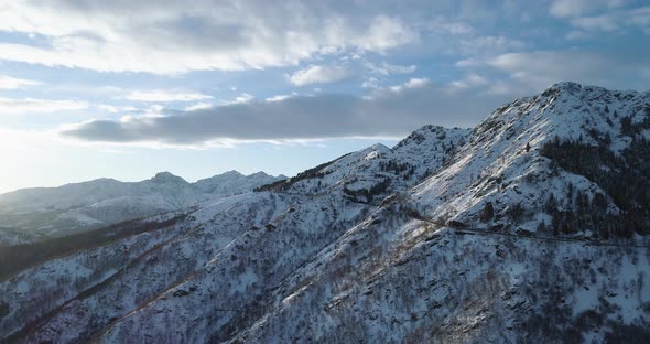 Backward Aerial Top View on White Snow Mountain in Winter