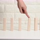 falling wooden blocks on a white table, finger pushes the first block - VideoHive Item for Sale