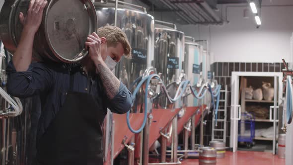 Man Carrying Heavy Beer Keg At Brewery