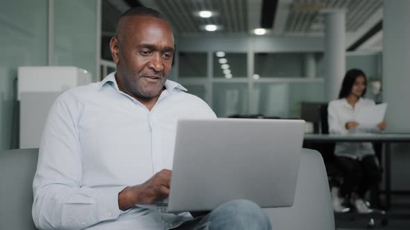 Elderly African Businessman Boss Sit at Coworking Space Modern Office with Laptop Use Computer