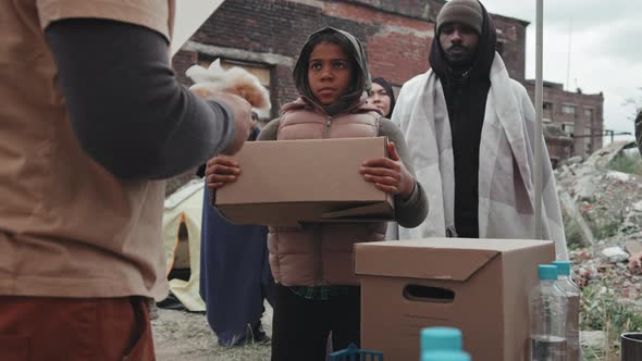 Refugee Girl Getting Food Supplies from Social Workers