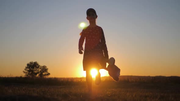 Little Girl in Dress Holding Teddy Bear Toy at Sunset