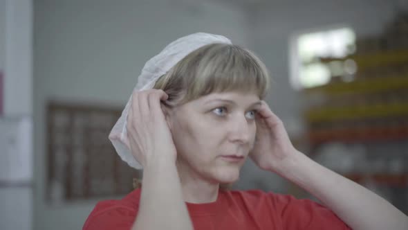 Portrait of Caucasian Woman Putting on Protective Hat on Factory and Leaving. Close-up of Expert