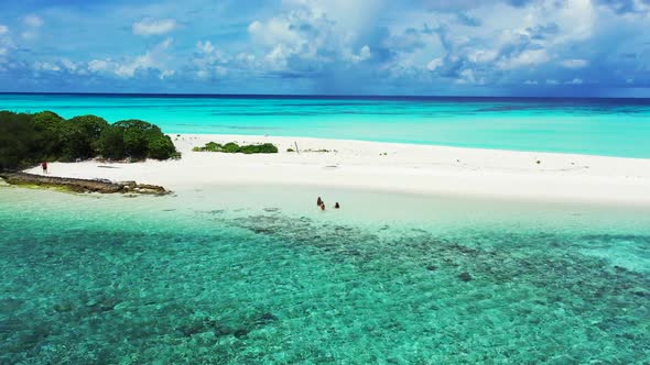 Women enjoying life on perfect lagoon beach wildlife by aqua blue lagoon and white sand background o