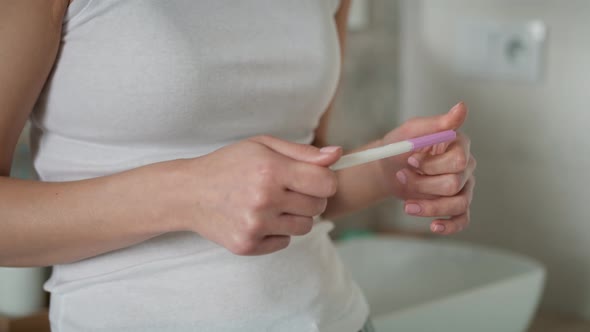 Detail of hands of unrecognizable stressed woman  waiting for pregnancy test results. Shot with RED