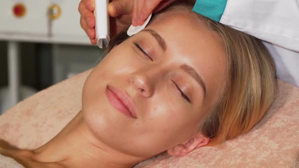 Happy Woman Smiling To the Camera While Getting Ultrasonic Facial Treatment