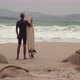 Man with Surfing Board Looks at Sea Waves Standing on Beach - VideoHive Item for Sale