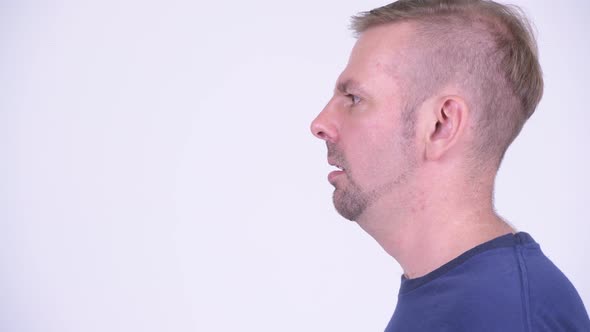 Head Shot Profile View of Angry Blonde Man Screaming