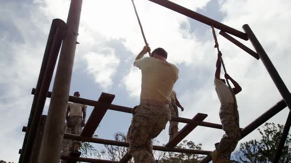 Military troops climbing rope during obstacle course 4k