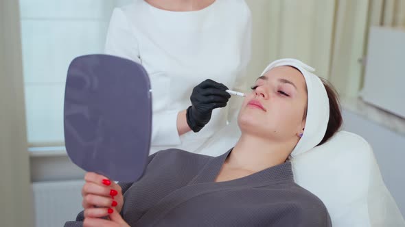 Woman in Appointing with Cosmetologist or Plastic Surgeon