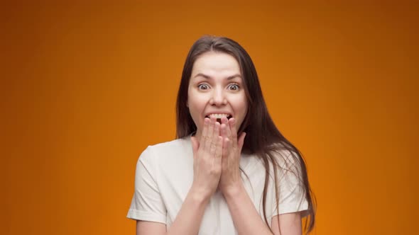 Portrait of Surprised and Shocked Woman Against Yellow Background