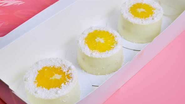 Small Cakes with Orange and Coconut Shavings in a Box