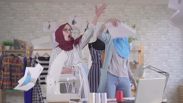 Two Positive Young Muslim Women Fashion Designers in National Headscarves Throw Papers for Joy Slow