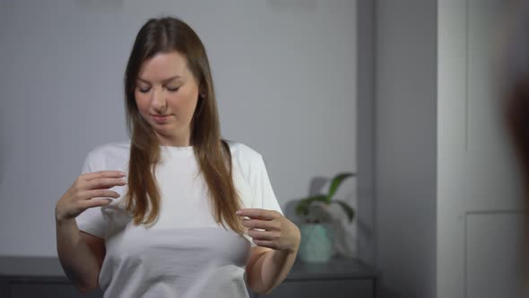 Young Woman Brushes Her Hair with a Comb