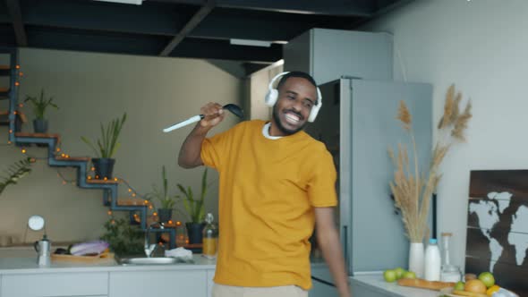 Happy Guy Dancing and Singing in Imaginary Microphone Having Fun in Kitchen in Apartment