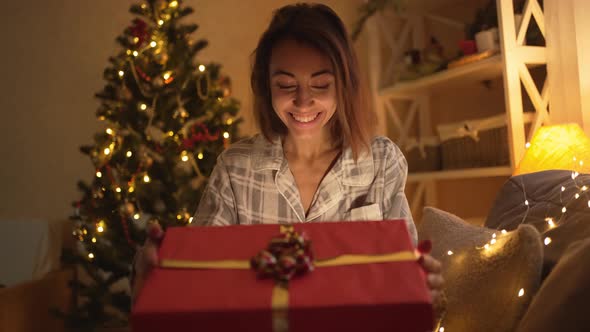 Slow Motion Happy Overjoyed Pretty Woman Opening Christmas Gift Box on Xmas Time Celebration at Home