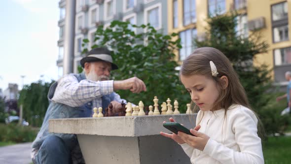Little Cute Girl Playing Game on the Smartphone