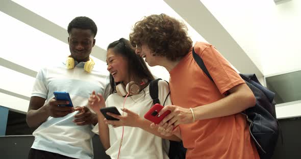 Three Teenage Multiethnic Students Chat on Cell Phones