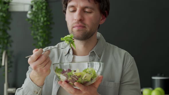 Man in Shirt Eating Salad in the Kitchen