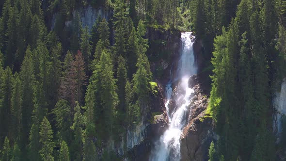 AERIAL REVERSING REVEAL of Iffigfall waterfall, Switzerland. Sunny summers day