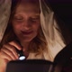 Woman Reads Book Under Blanket in the Dark and Illuminates the Pages of the Book with Flashlight - VideoHive Item for Sale