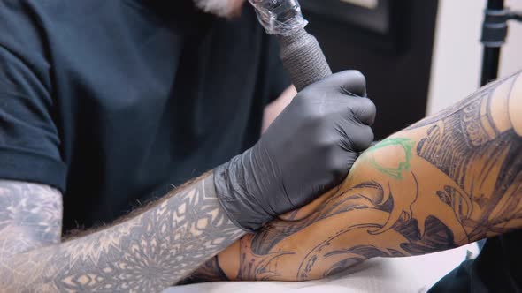 The Process of Tattooing a Man's Hand in a Tattoo Parlor