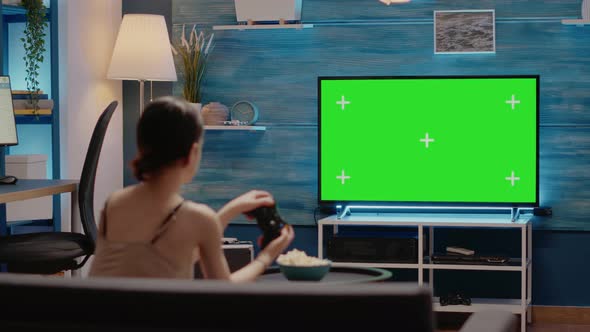 Person Using Joystick and Green Screen Display on Tv