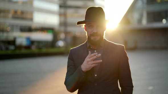 Confident and Successful Man is Smoking Cigarette Outdoors in Modern City District