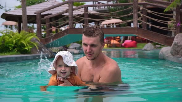 Carrying Loving Young Father Teaching Playful Baby Toddler to Swim in Pool on Summer Tropical Resort