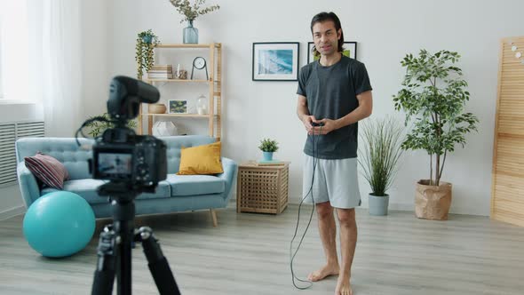 Mixed Race Man Skipping on Jumping Rope and Recording Video for Internet Vlog at Home