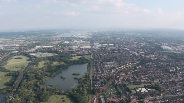 High drone shot of long straight train tracks separating UK town from natural reserve