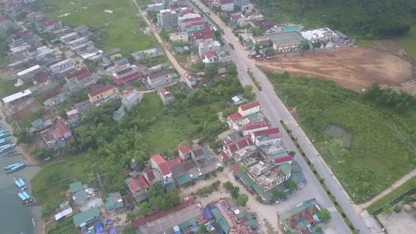 Asphalt Road Runs Along Lively Village Located on River Bank