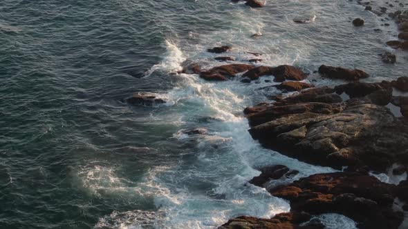 Perfect waves splashing on the rocky shores of Gloucester, Massachusetts -aerial