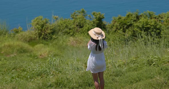 Woman look at the sea view on green lawn