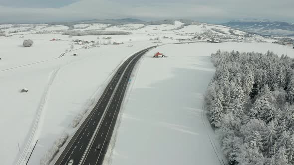 Aerial of highway running through beautiful snow covered landscape