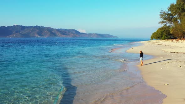 Lady alone happy and smiling on relaxing lagoon beach holiday by shallow sea and white sand backgrou